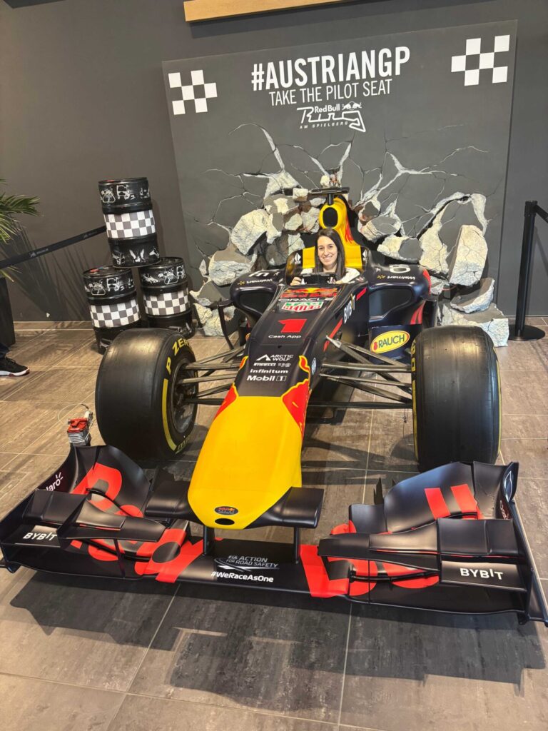 Mircsi sits smiling in an older Red Bull F1 car
