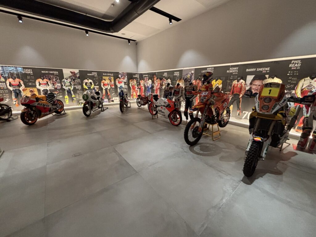 All motoGP champions' racesuits and a few bikes in the foreground.