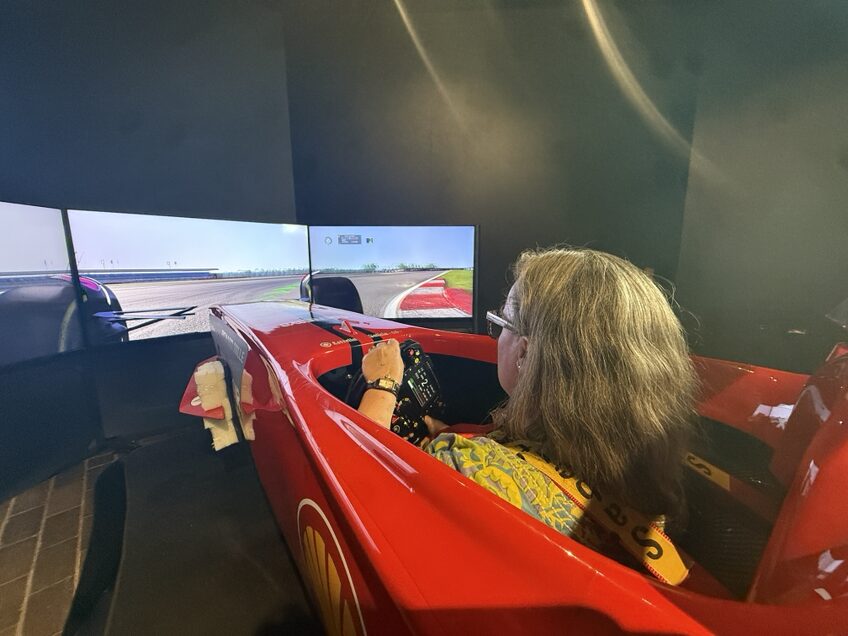 Woman sitting in a Ferrari style racing simulator